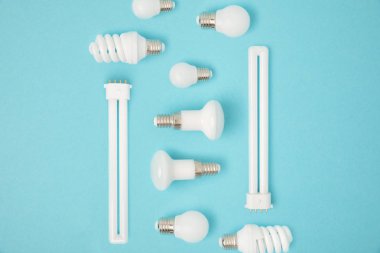 flat lay with arranged various light bulbs isolated on blue clipart