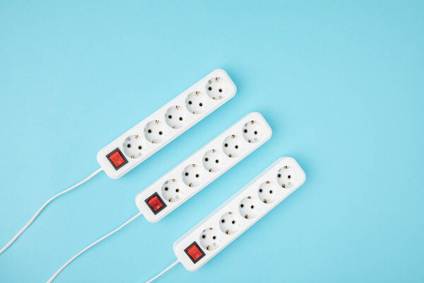 top view of arrangement of extension cords isolated on blue