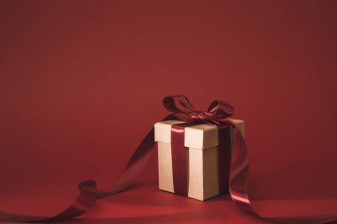 close up view of present decorated with ribbon on red clipart