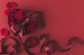 pohled shora růží v srdci ve tvaru krabičky s pásu karet a lístků izolovaných na červenou, st Valentýn svátek koncept