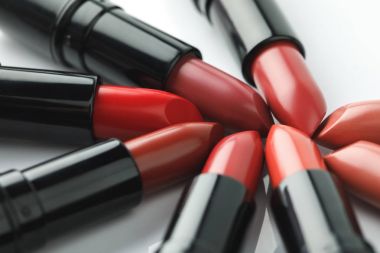 close-up shot of red lipsticks of various shades on white tabletop