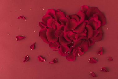 top view of heart made of roses petals isolated on red clipart