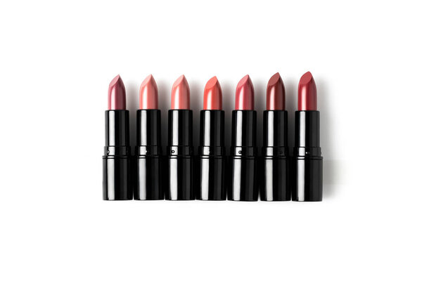 верхний вид помады, лежащей на белой столешнице, расположенной в ряд
