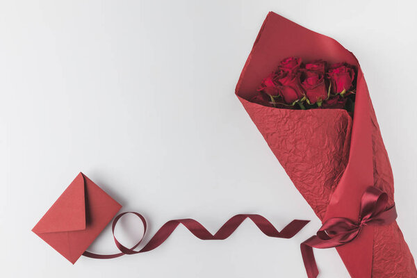 плоский уголок с букетом роз, ленты и конверта, изолированные на белом, День святого Валентина праздничной концепции
