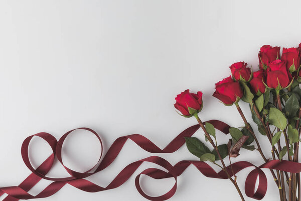 top view of beautiful red roses with ribbon isolated on white, st valentines day concept