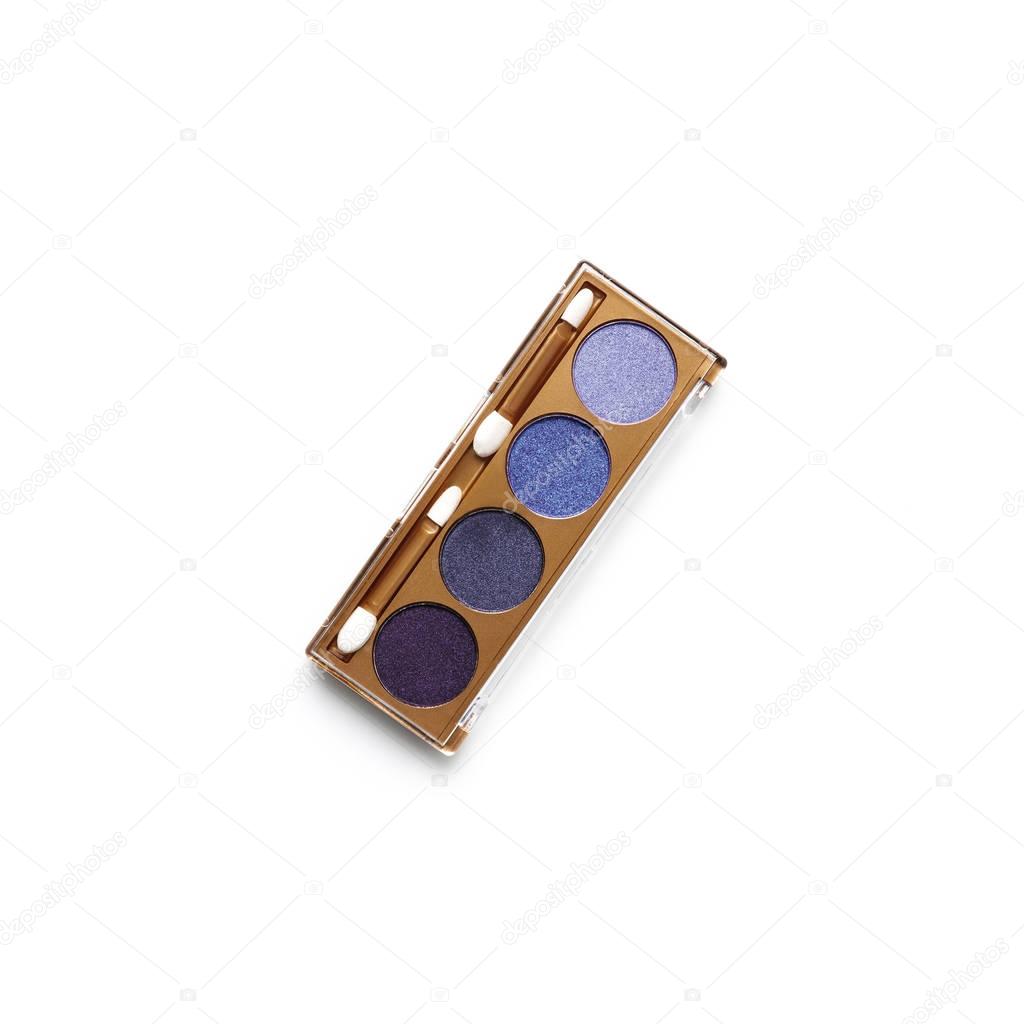 top view of container with different shaded purple cosmetic eye shadows isolated on white