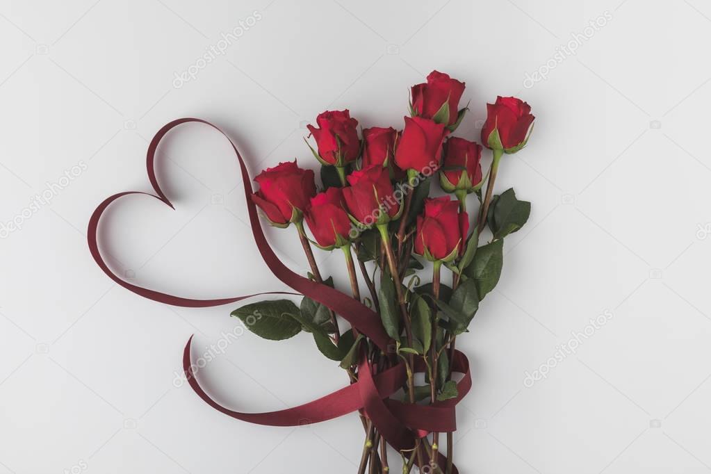 top view of beautiful red roses with ribbon isolated on white, st valentines day concept