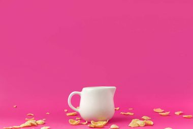 close-up view of jug with milk and crunchy corn flakes on pink clipart
