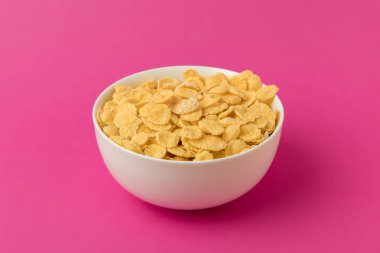 Beyaz kase tatlı lezzetli mısır gevreği pink izole ile yakından görmek 