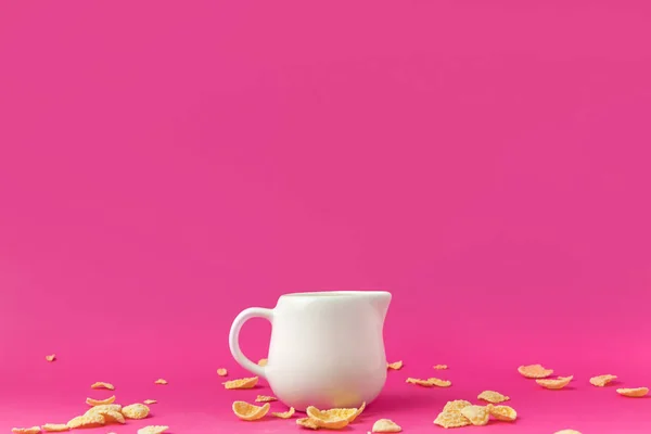 Nahaufnahme Von Krug Mit Milch Und Knusprigen Cornflakes Auf Rosa — kostenloses Stockfoto