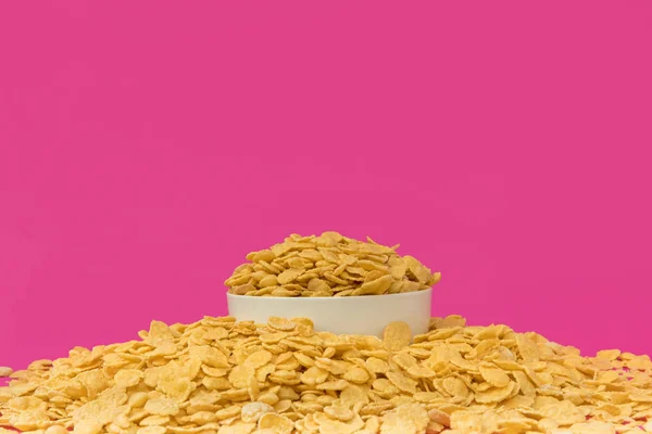 白色的碗与甜脆的玉米片在粉红色隔离的近距离查看 — 免费的图库照片