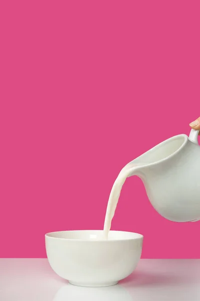 Împușcat Mână Turnând Lapte Proaspăt Ulcior Castron Roz — Fotografie, imagine de stoc