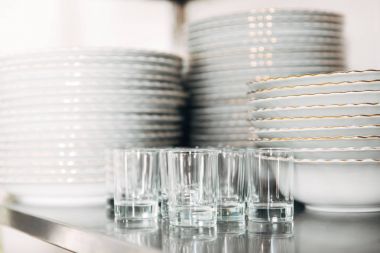 close-up shot of stacked clean tableware and glasses at restaurant clipart