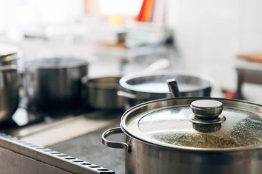 close-up shot of sauce pans at restaurant kitchen clipart