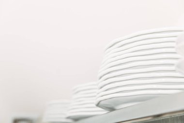 close-up shot of stacks of clean tableware at restaurant on shelf clipart