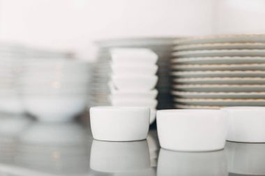 close-up shot of stacks of various clean tableware at restaurant clipart