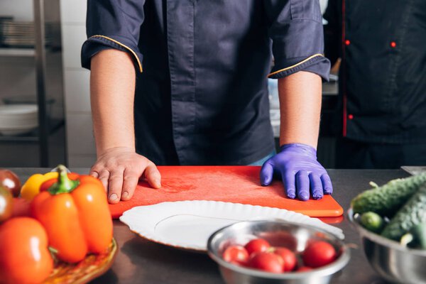 cropped shot of chef standing at workplace in restaurant