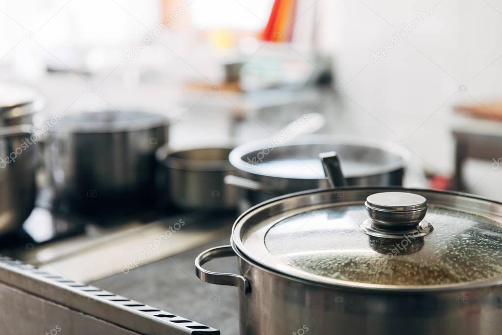 close-up shot of sauce pans at restaurant kitchen