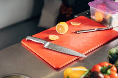 cutting board with knife and halved lemon at restaurant kitchen clipart