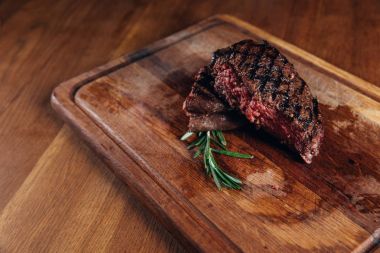 medium rare grilled steak on wooden board clipart