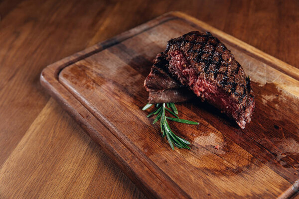 medium rare grilled steak on wooden board