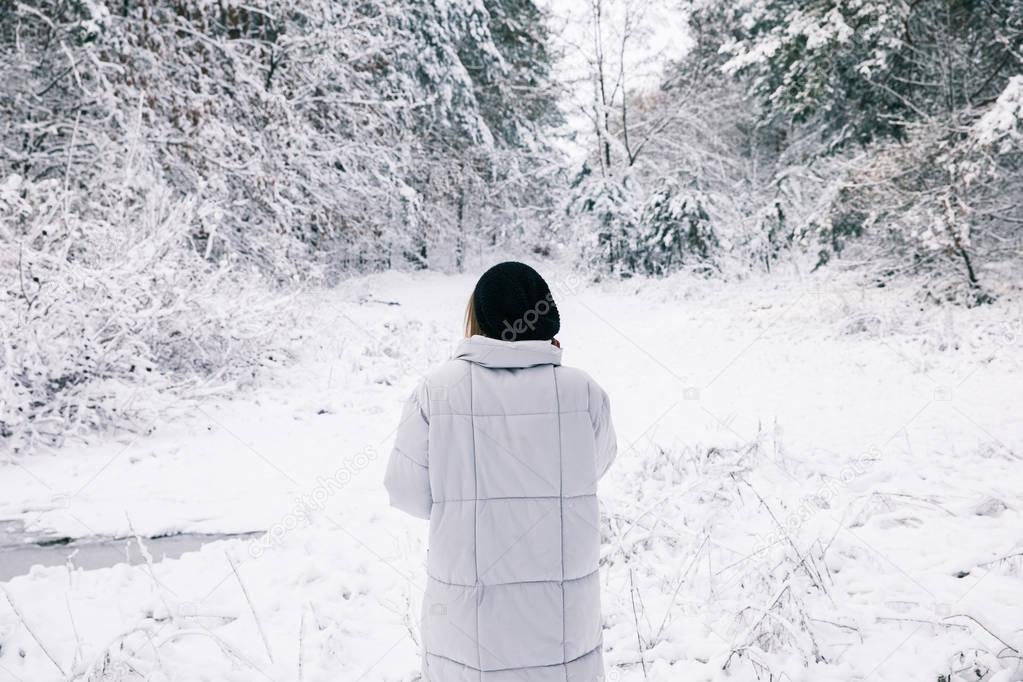 rear view of woman walking in snowy forest