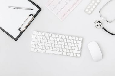 keyboard surrounded by paper in folder, computer mouse, stethoscope isolated on white background    clipart