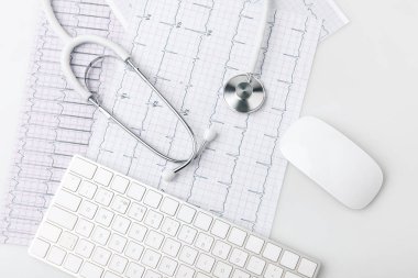 Beyaz arka plan üzerinde izole kardiyogram ile kağıt üzerinde döşeme stetoskop, klavye ve bilgisayar fare     