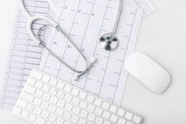 stethoscope, keyboard and computer mouse laying on paper with cardiogram isolated on white background      clipart