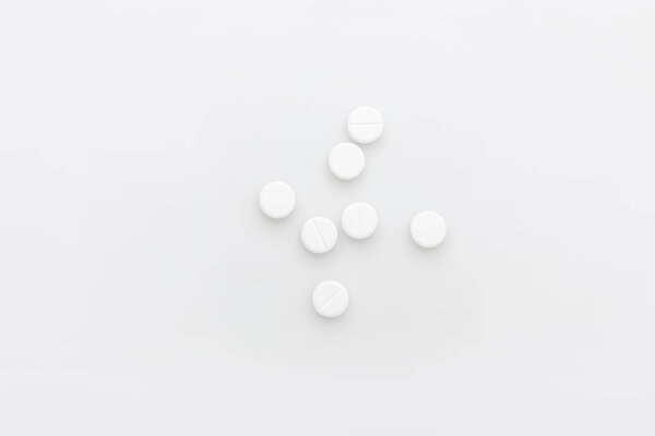 рассеянные белые таблетки изолированы на белом фоне
   
