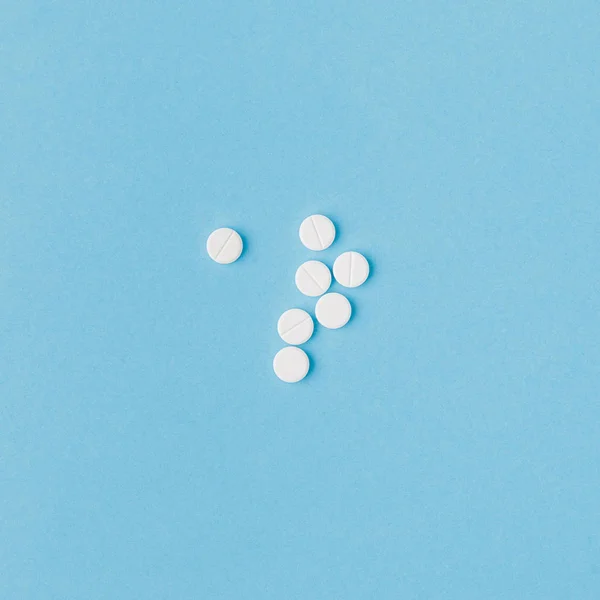 Comprimidos Brancos Dispersos Isolados Fundo Azul — Fotografia de Stock