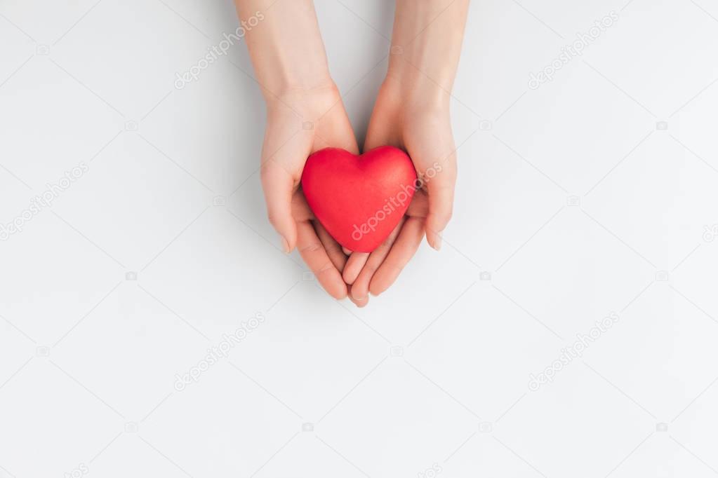 top view of hands holding red heart isolated on white background   