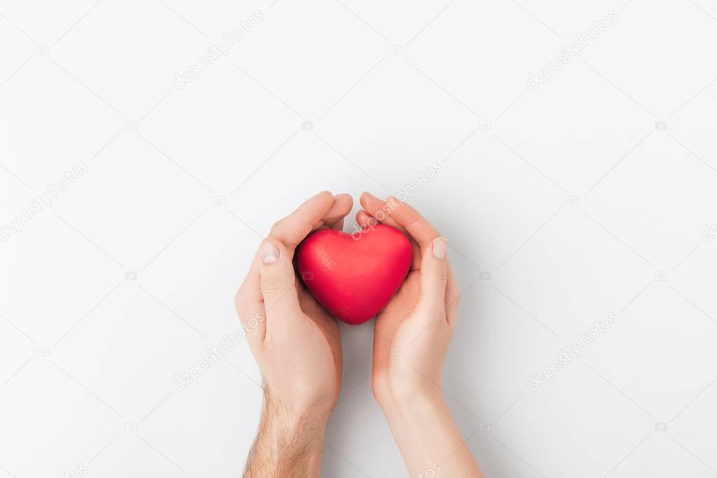 top view of hands holding red heart isolated on white background   