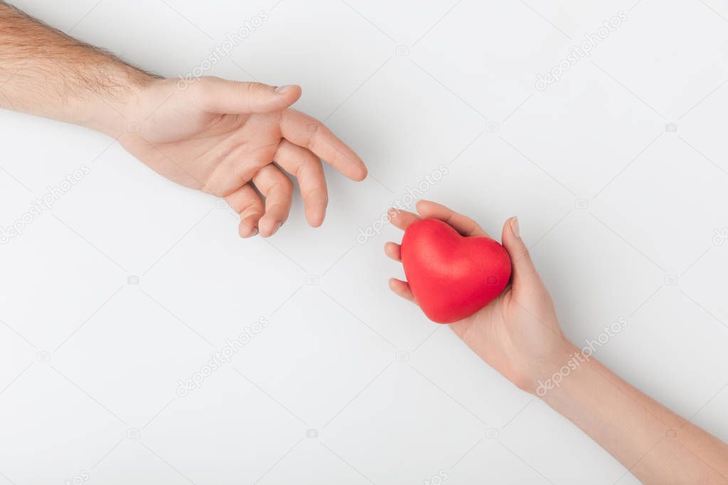 cropped view of hands with red heart isolated on white background