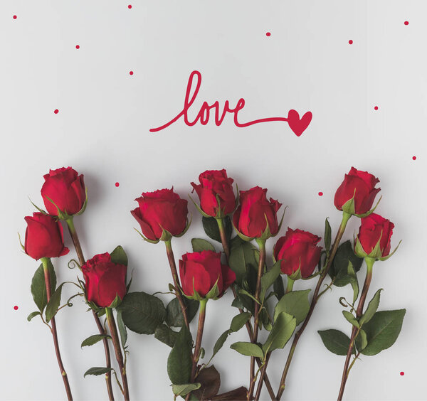 top view of arranged red roses isolated on white