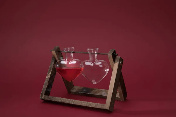 Herzförmiges Glas Mit Parfüm Und Leerem Glas Auf Holzständer Auf — kostenloses Stockfoto