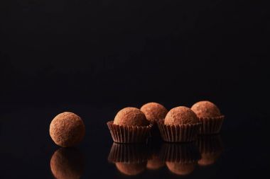close up view of tasty truffles on black clipart