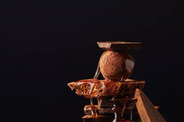 siyah izole karamel ve çikolata çubuklarla trüf düzenlemenin görünümü kapatın