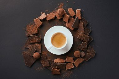 görücü usulü fincan kakao tozu ile kahve, yer mantarı ve çikolata çubukları üstten görünüm üzerinde gri masa üstü