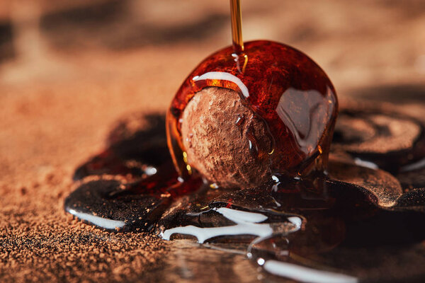 close up view of pouring caramel onto truffle process