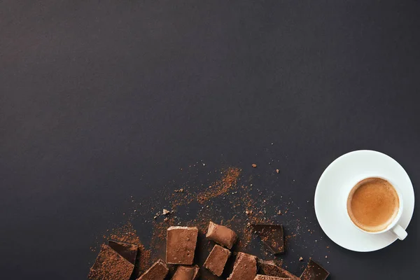 灰色の卓上にココア パウダーとコーヒー トリュフ チョコレートのバーの配置のカップの上から見る — ストック写真