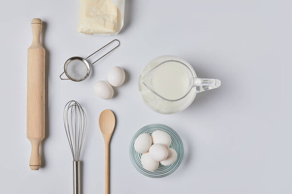 top view of eggs and milk on white table