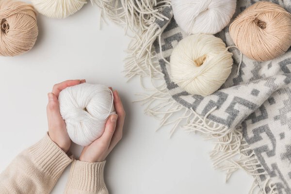 cropped view of woman holding white yarn ball on white background 