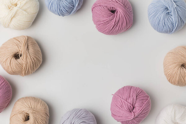 top view of scattered colored yarn balls  on white background 