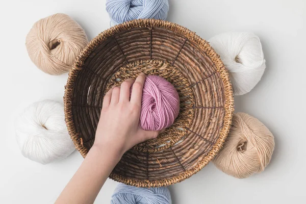Cropped view of woman holding pink yarn ball in hand in wicker basket on white background — Stock Image Cropped View Woman Holding Pink Yarn Ball Hand Wicker Basket Stock Image