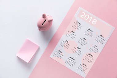 top view of arranged piggy bank, empty notes and 2018 calendar  clipart