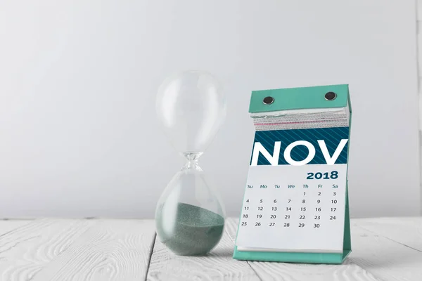 Vista Cerca Del Reloj Arena Calendario Noviembre Mesa Madera Aislado —  Fotos de Stock