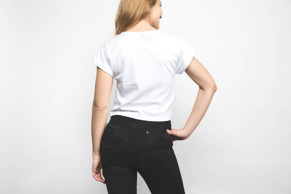 back view of young woman in blank t-shirt on white