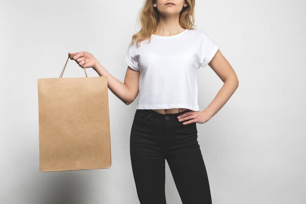 cropped shot of woman in blank t-shirt on white with shopping bag