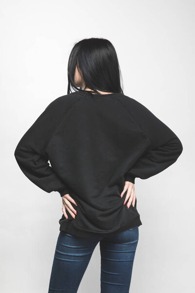 back view of young woman in blank sweatshirt on white